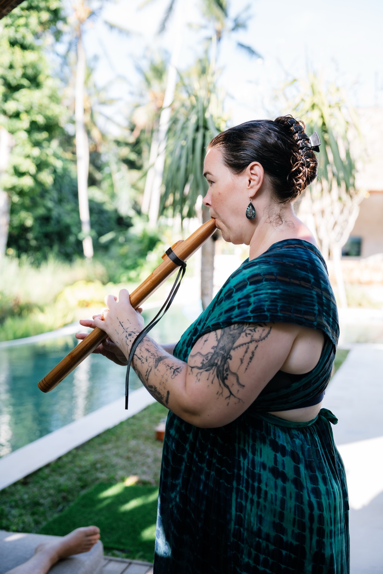 Kelly playing flute by pool